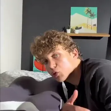 Hombre sentado en la cama comparando una almohada plana con la almohada cervical
